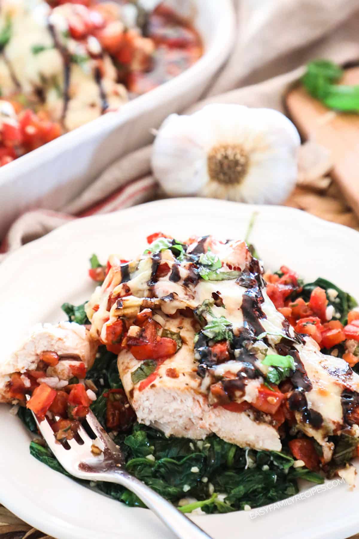 Baked bruschetta Chicken served over spinach