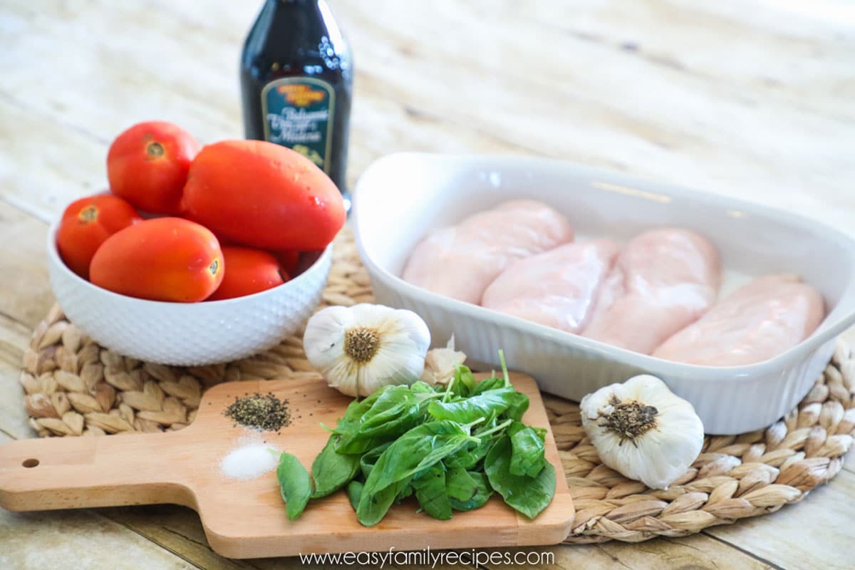 Ingredients for Baked Bruschetta Chicken including chicken breast, tomatoes, basil, garlic, and balsamic vinaiger
