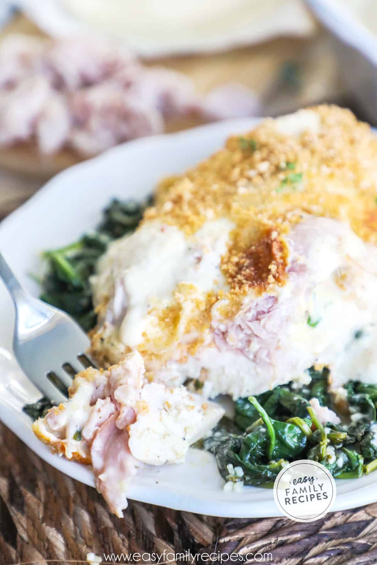 Easy Baked Chicken Cordon Bleu served on a bed of spinach.