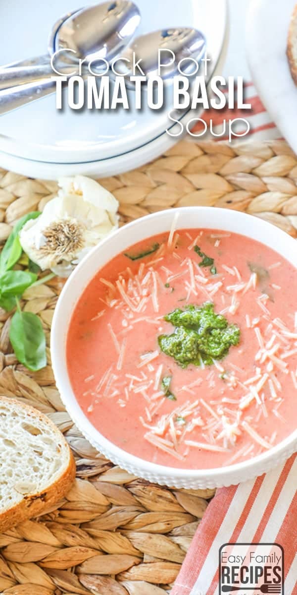 CrockPot Tomato Soup in Bowl next to garlic cloves, basil and french bread