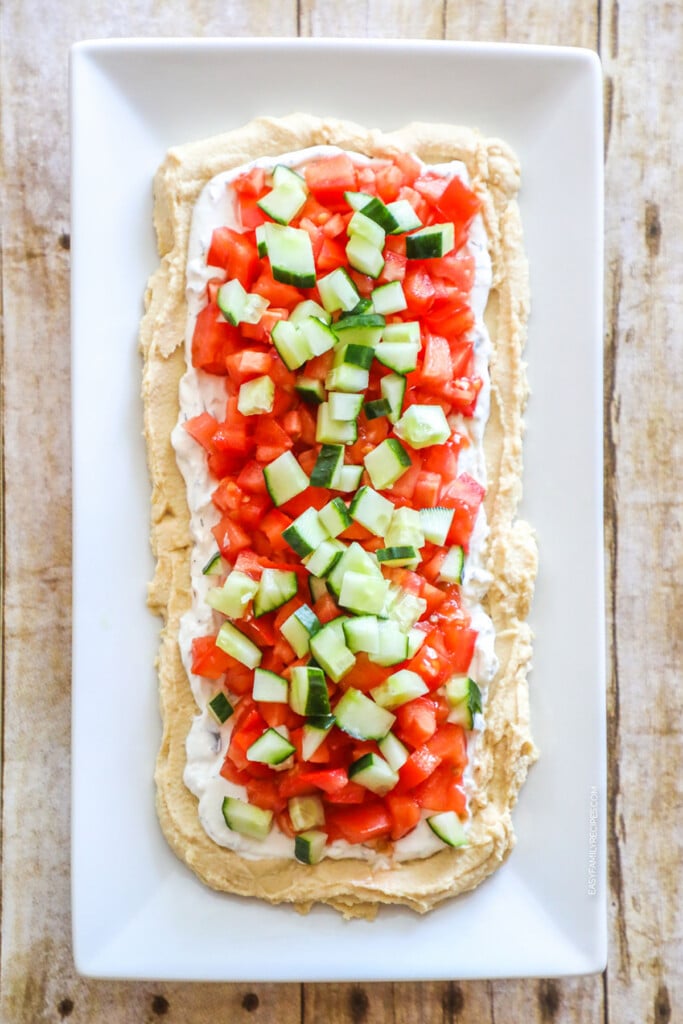How to make Layered Greek Dip Step 2: add cucumber and tomato.
