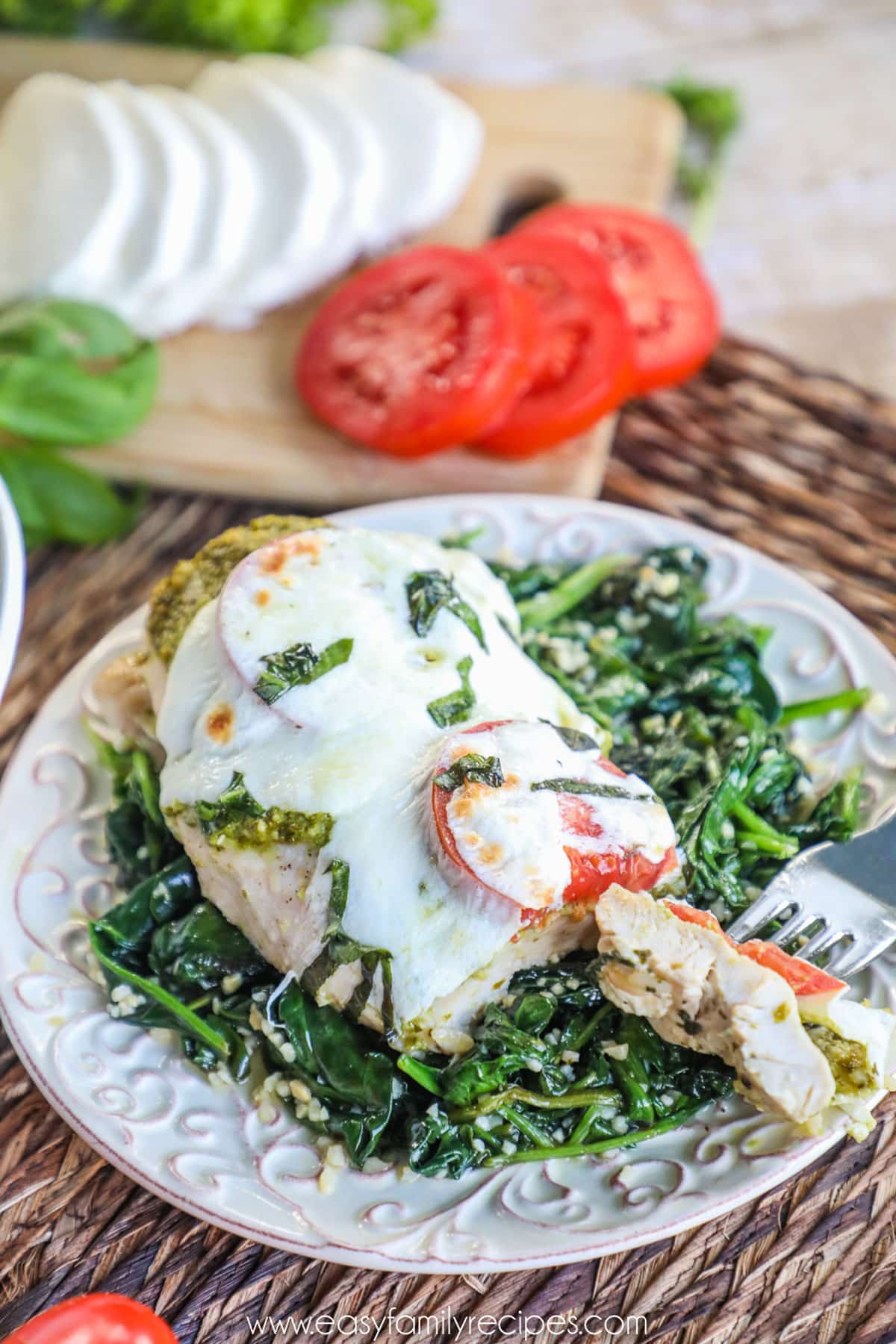 Caprese chicken served on a bed of spinach