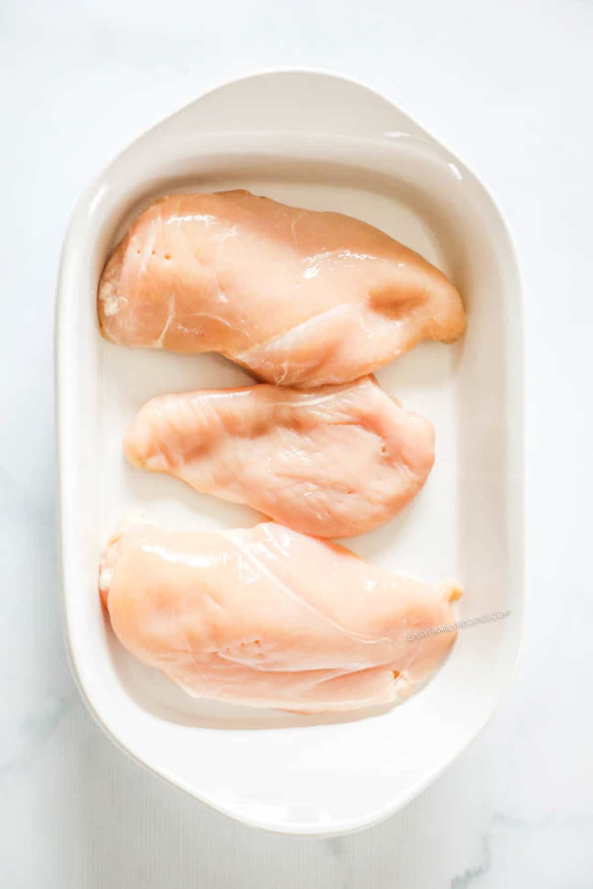 Steps for making tuscan garlic chicken - Step 1: place raw chicken breast in dish