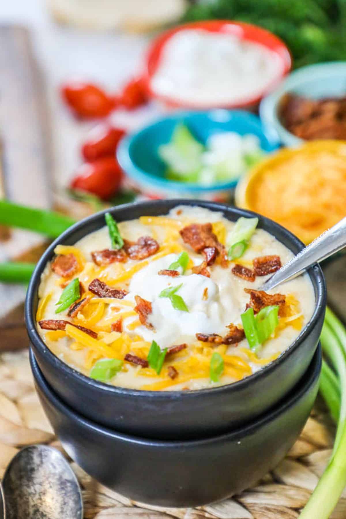 Loaded Baked Potato Soup in a bowl topped with sour cream, chives, and bacon.