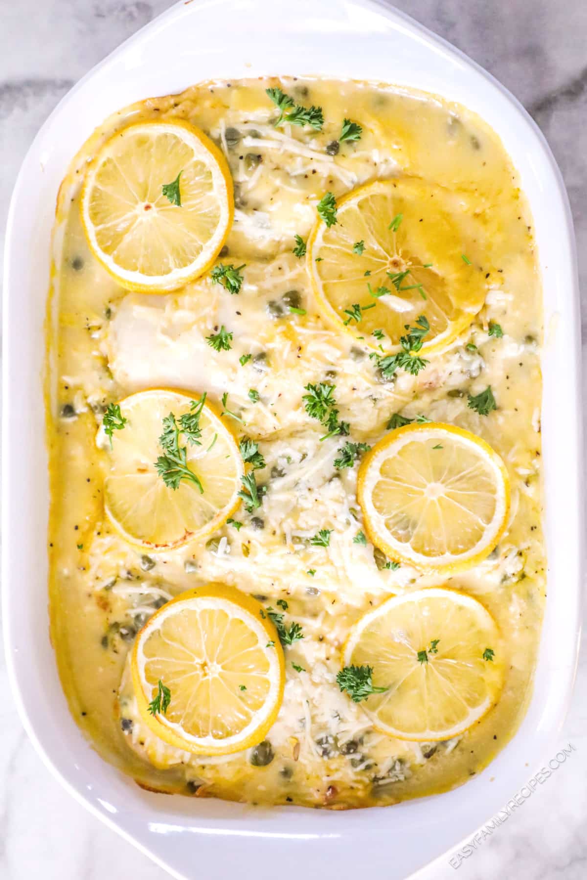 Chicken Piccata Casserole garnished with lemon slices and parsley.