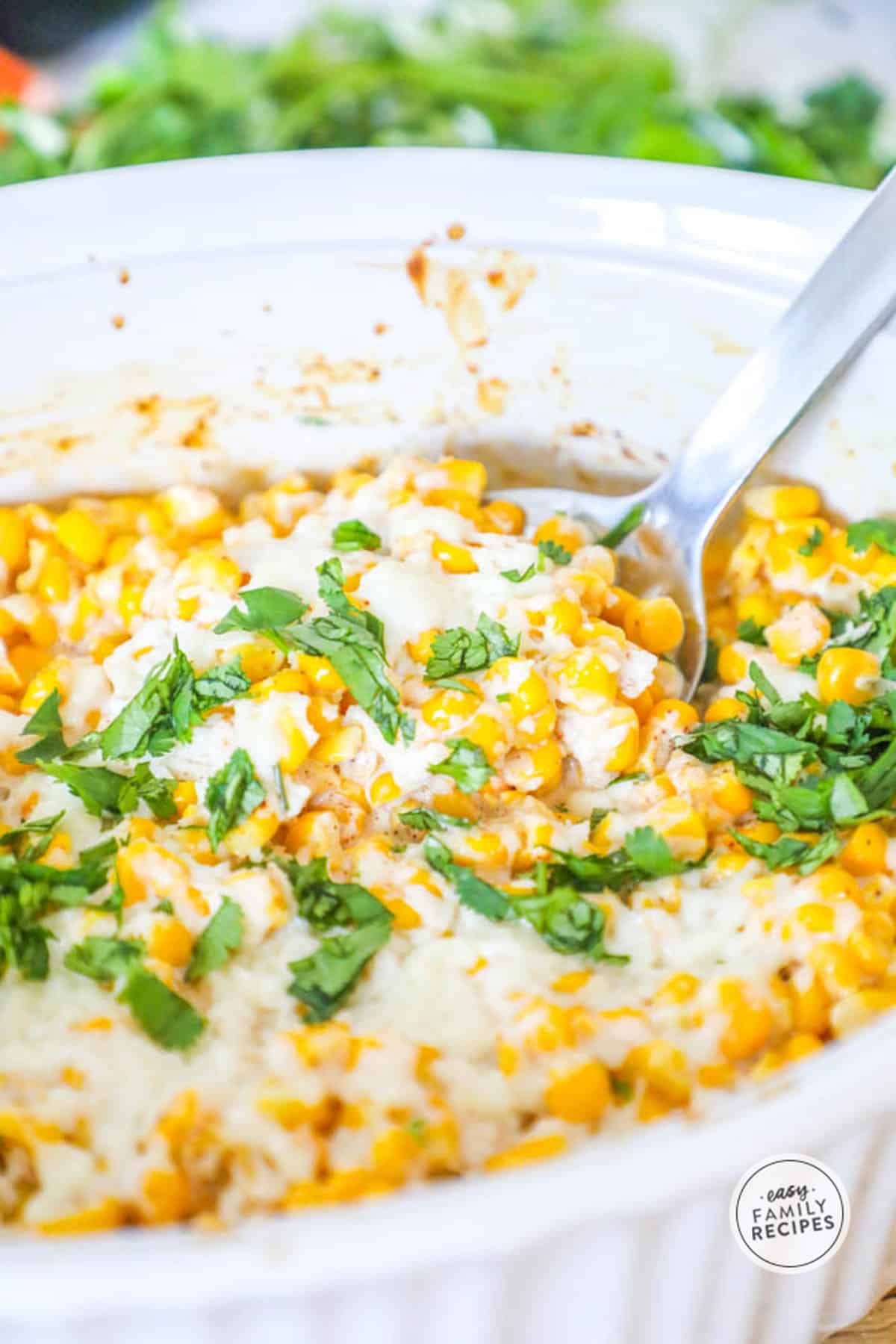 Scooping a spoonful of Baked Mexican Corn Casserole from serving dish