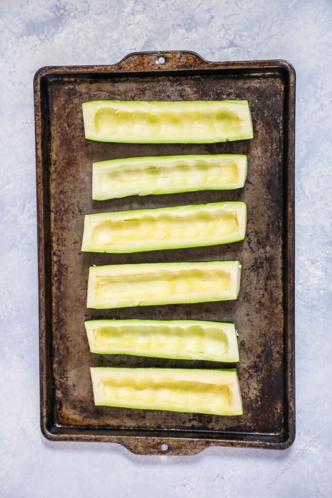 How to Make Taco Stuffed Zucchini Boats Step 1: Cut zucchini in half and hollow out the center.