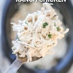 Spoon lifting up slow cooker ranch chicken with cream cheese