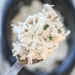 Scooping a big spoonful or creamy ranch chicken out of the crockpot