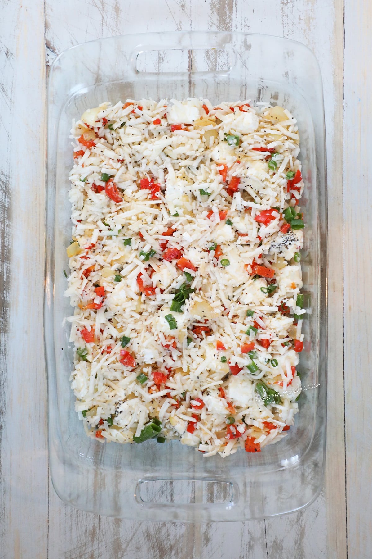 step 2 of how to make breakfast sausage and hashbrown casserole: spread mixture in a greased 9×13″ casserole dish