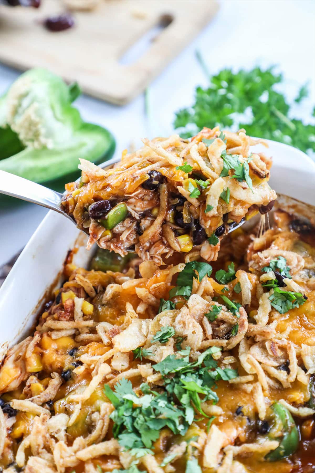 Scooping BBQ Chicken Casserole out of baking dish.