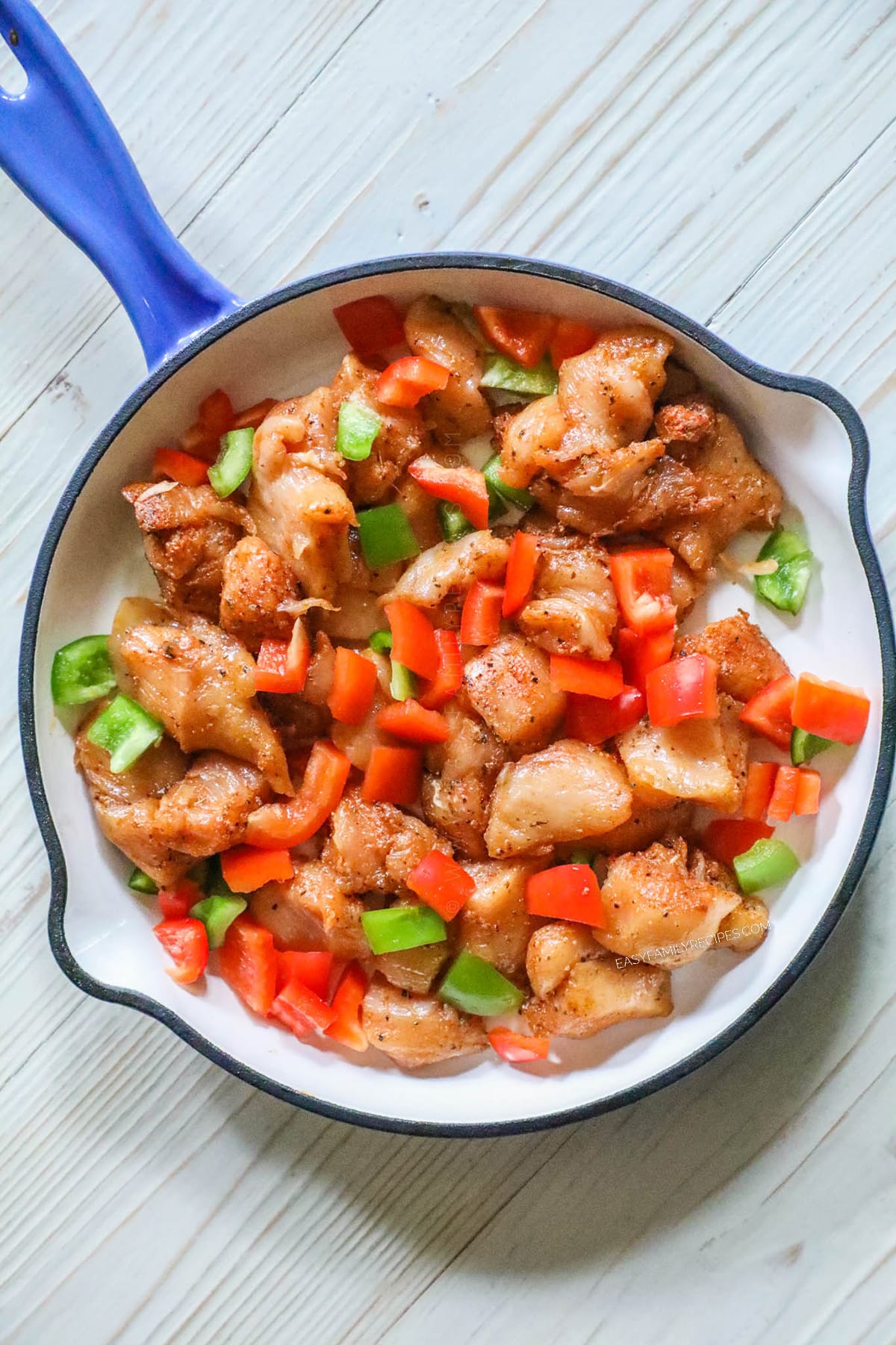 step 2 image - Add the chicken and peppers to the skillet in a single layer.