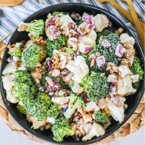 Broccoli salad with bacon and cauliflower in serving bowl.