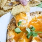 Dipping a chip into baked chicken fajita dip.