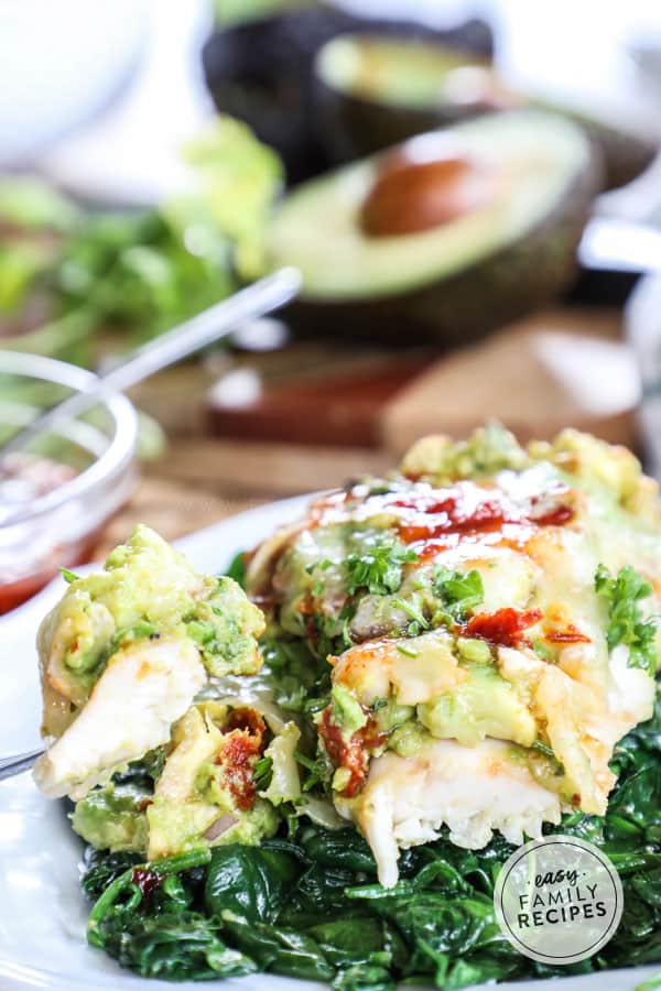 Avocado Smothered Chicken Breast served on spinach