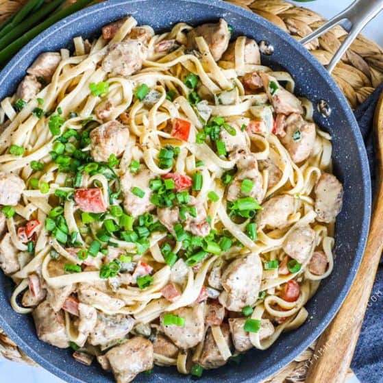 Creamy Cajun Chicken Pasta in a Skillet topped with green onions