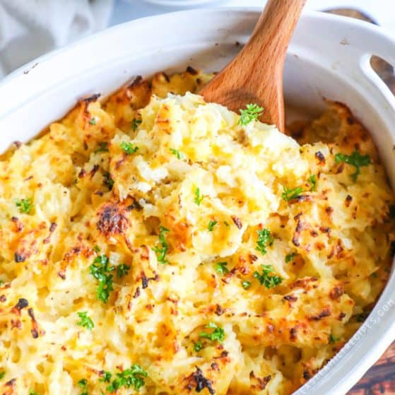 Spoon serving Easy Hashbrown Casserole out of baking dish