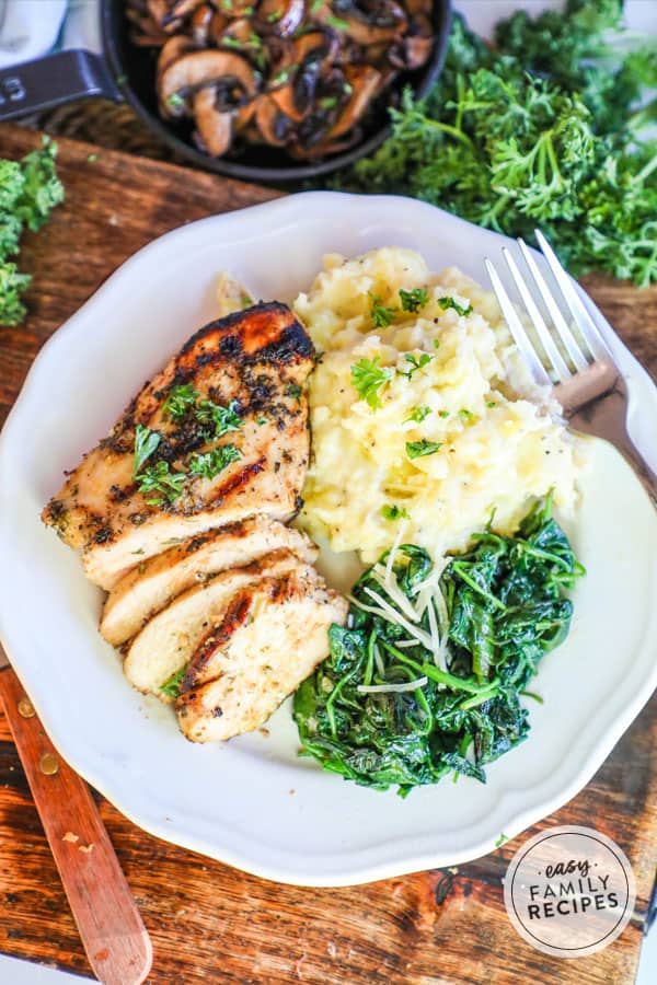 Grilled Apple Cider Vinegar Marinated Chicken served on a plate with spinach and mashed potatoes