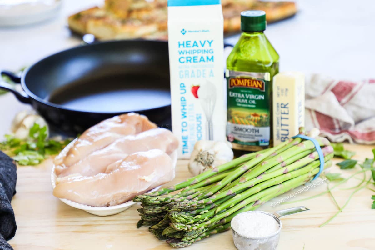 Ingredients for making Creamy Chicken and Asparagus including chicken breast, fresh asparagus, cream, butter, garlic and flour