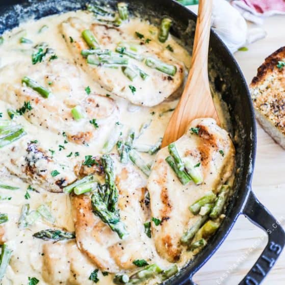 Chicken and Asparagus coverer with cream sauce in a cast iron skillet