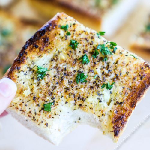 Slice of hot homemade garlic bread with herbs
