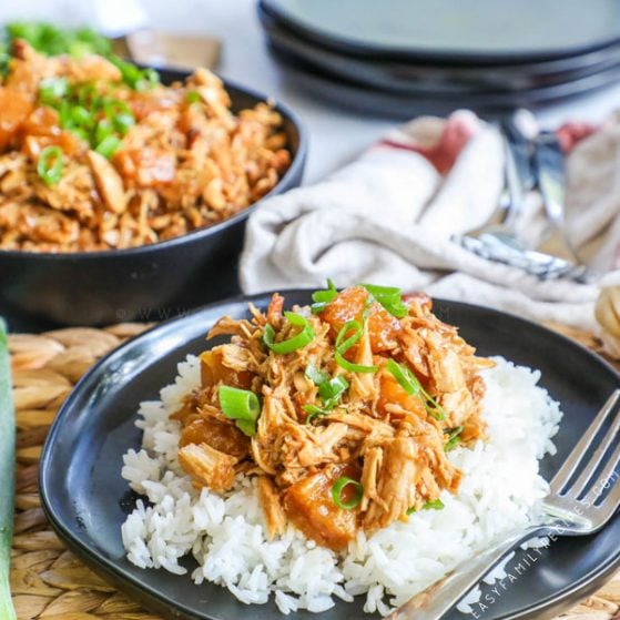 Plate of Crockpot Pineapple Chicken over Rice with a fork