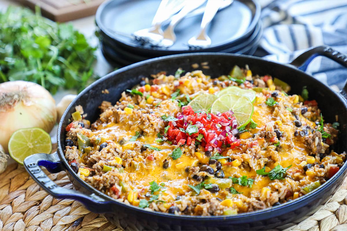 Easy Mexican Ground Beef and Rice recipe prepared in a skillet and set on a table.