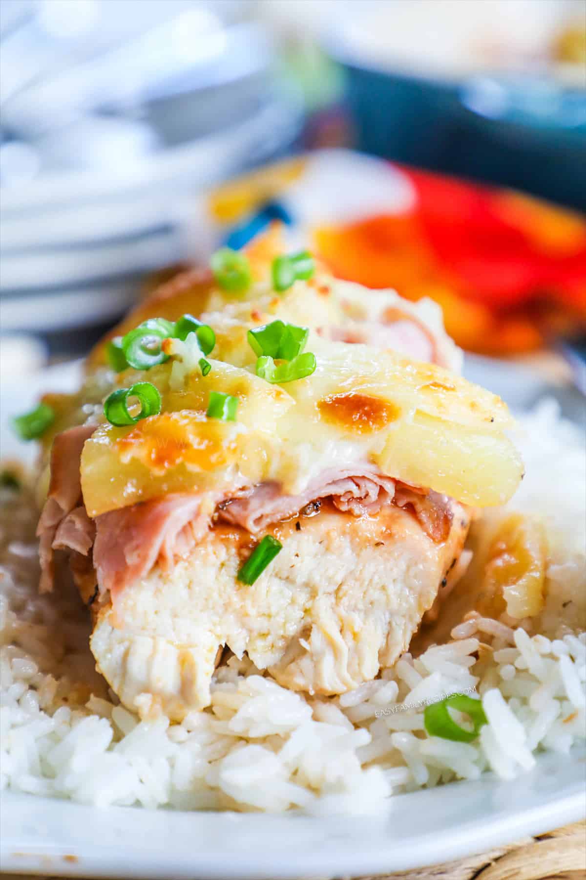 View of sliced baked Hawaiian Chicken layered with cheese, ham, bbq sauce and pineapples