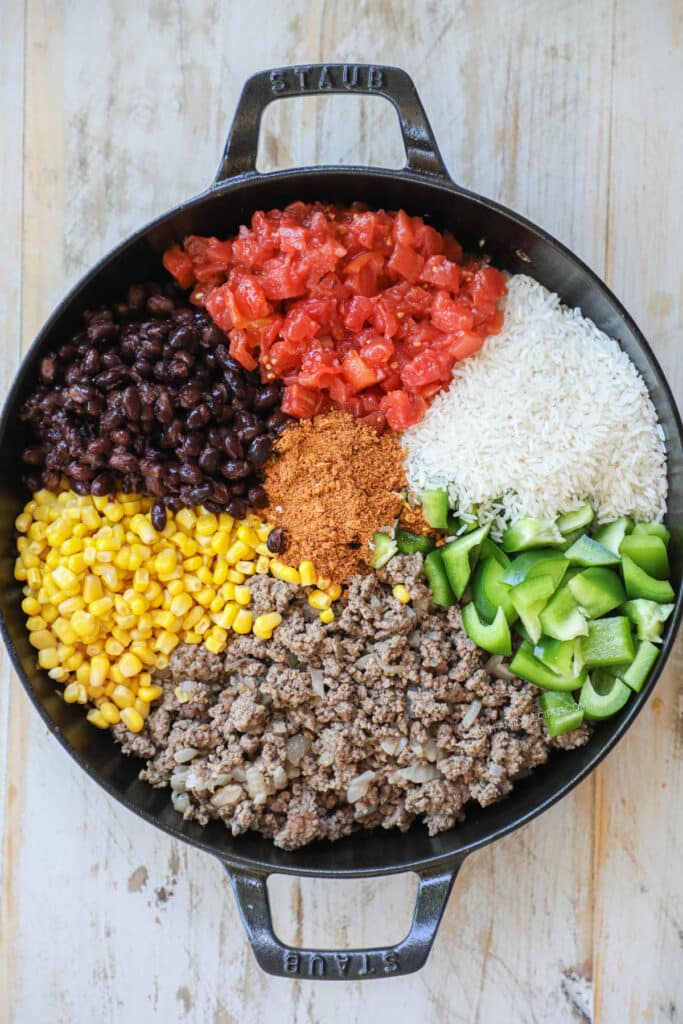 How to make Mexican ground beef skillet step 3: add corn, black beans, tomatoes, rice, bell pepper and seasoning.