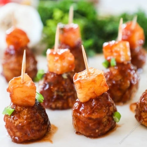 Hawaiian Meatballs made in the crockpot on a toothpick with a pineapple chunk