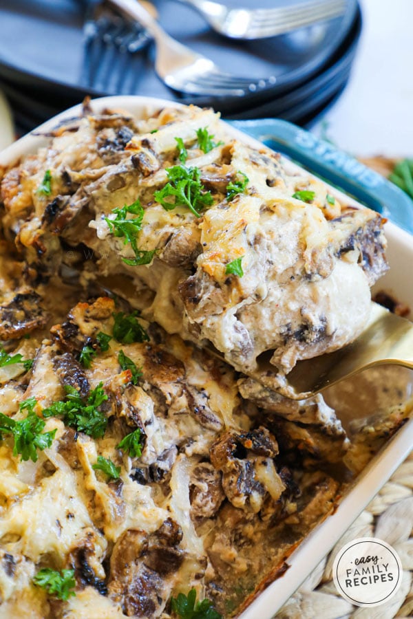 Baked Mushroom Chicken being lifted from the casserole dish