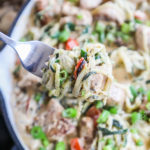Fork lifting creamy low carb chicken Alfredo made with Zoodles