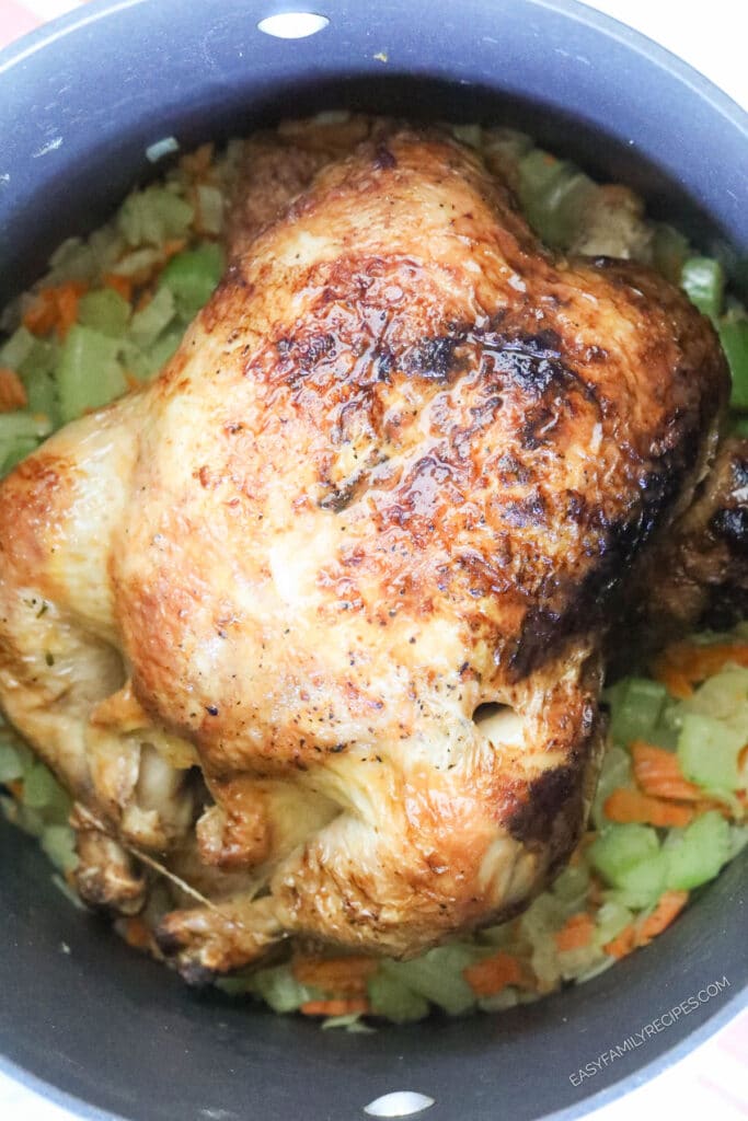 How to makechicken noodle soup with rotisserie chicken step 2: Add the whole rotisserie chicken into the pot and cover with broth, then simmer.