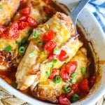 Lifting chicken out of the baking dish with a spatula.