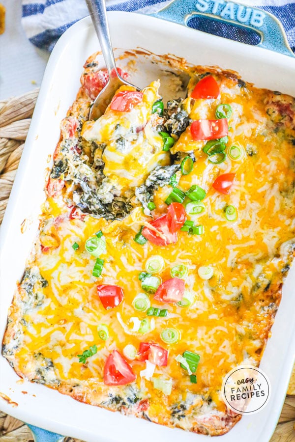 Hot Mexican Spinach Cheese Dip baked in a casserole dish and served with a spoon