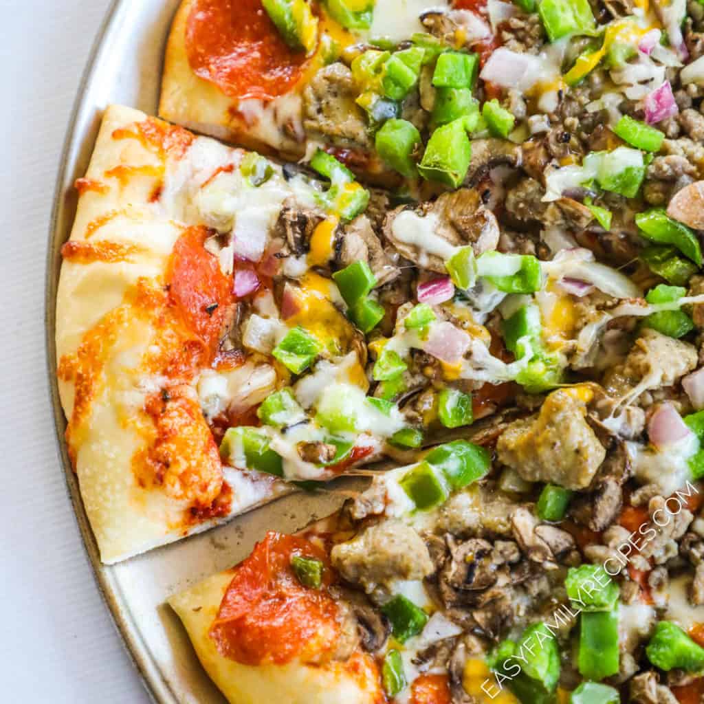 Pizza topped with sausage, green pepper, onion, pepperoni, cheese