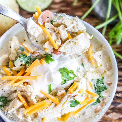 Cream Cheese Chicken Chili in bowl topped with sour cream and cheddar cheese