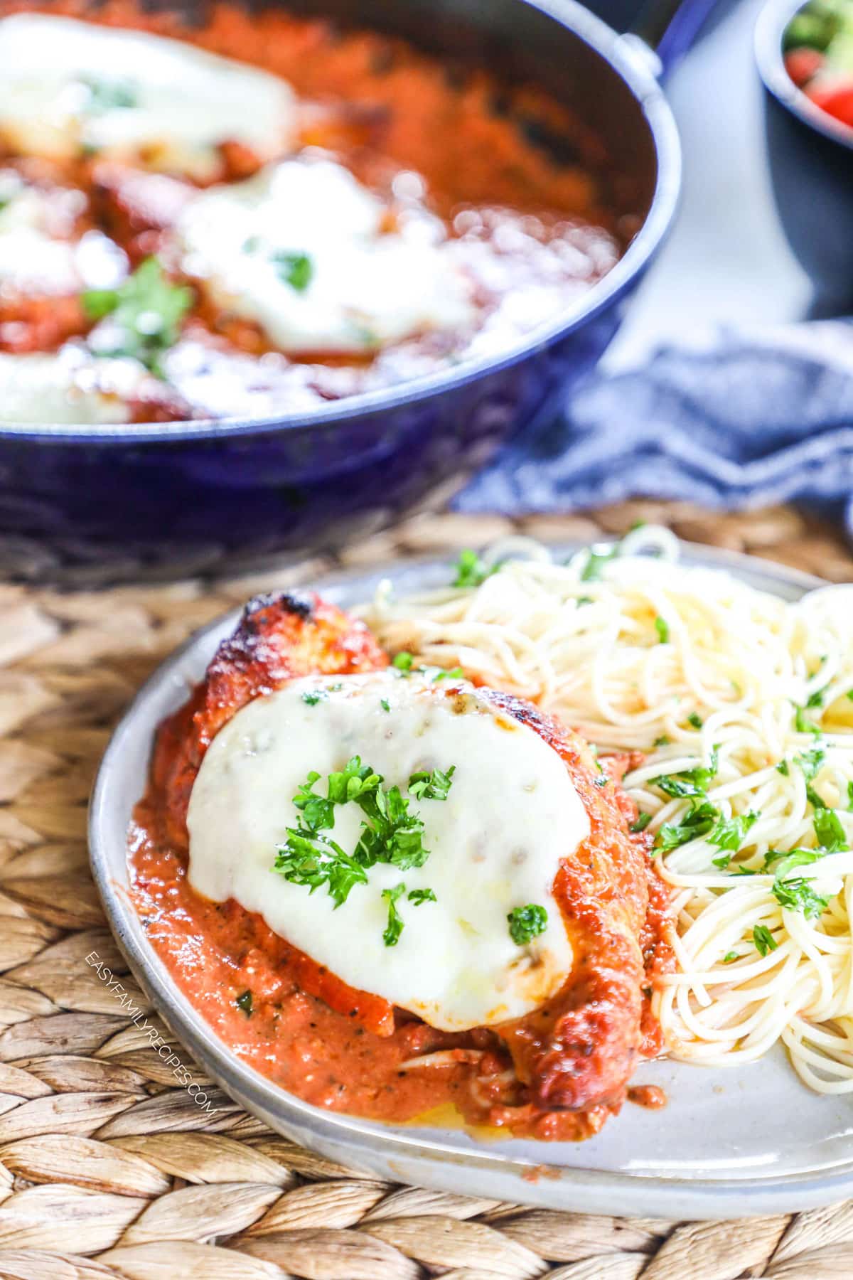 Chicken Mozzarella in creamy tomato sauce topped with basil and plated with pasta