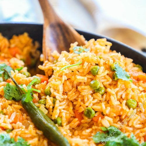 close up of Mexican style rice with peas being scooped onto a spoon