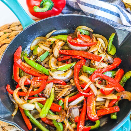 sauteed red and green bell peppers and onion in a skillet that have been cooked