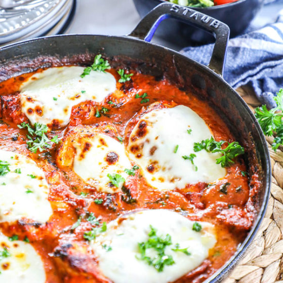 Mozzarella topped Chicken in a creamy tomato sauce shown in a skillet