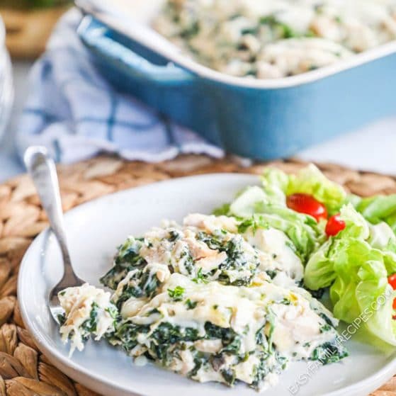Chicken Florentine Casserole scooped onto a plate with casserole dish behind it