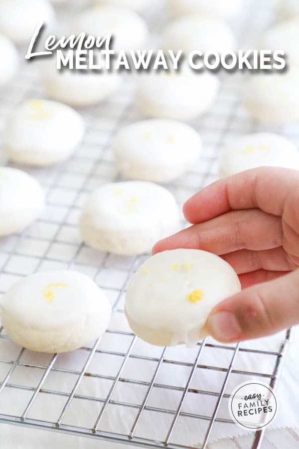 Hand picking up a lemon cookie with glaze