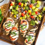 Chicken breast topped with tomato, mozzarella, and basil cooked on a sheet pan with veggies