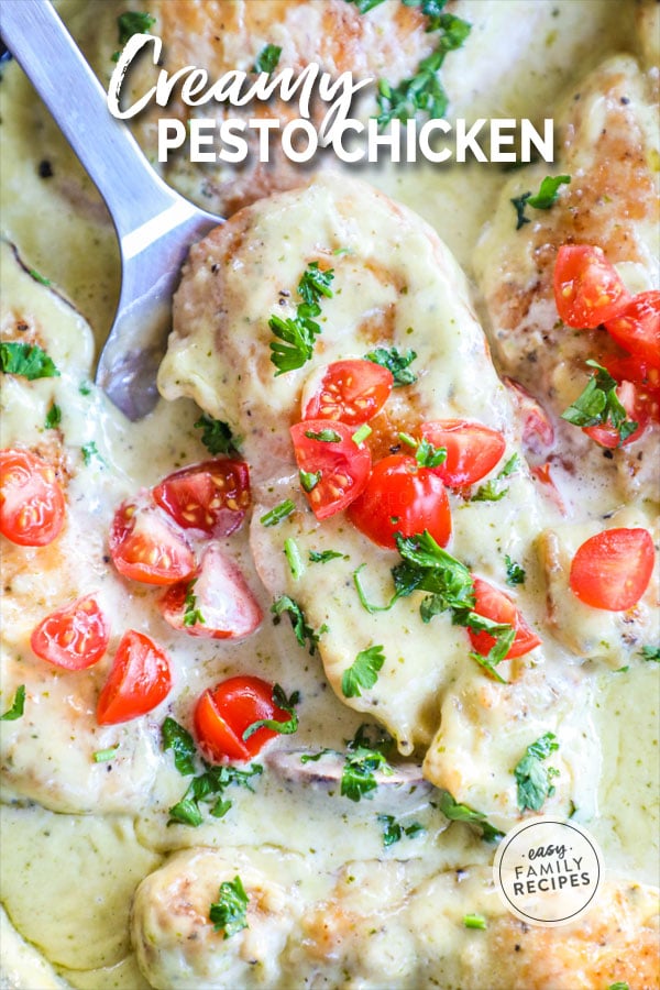 Spatula lifting chicken with pesto cream sauce on it out of the pan