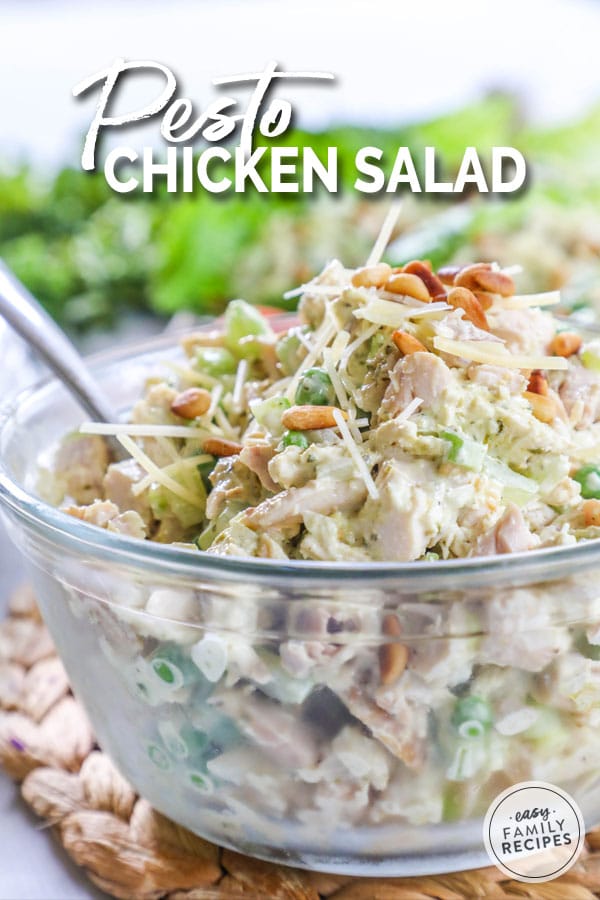 Pesto Chicken Salad served in a large glass bowl garnished with pine nuts and parmesan cheese