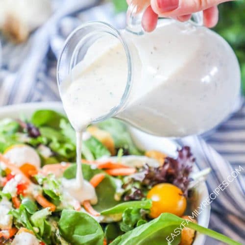 Homemade Creamy Italian Salad Dressing being poured onto a salad