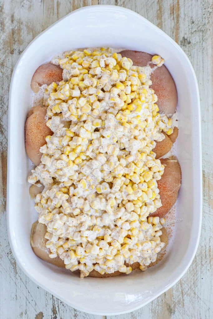 How to make Mexican Street Corn Chicken Step 3: Spread elote topping on top of chicken in baking dish.