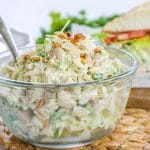 Pesto Chicken Salad prepared in a glass bowl with a spoon