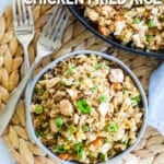 Chicken fried rice in a bowl with skillet in background